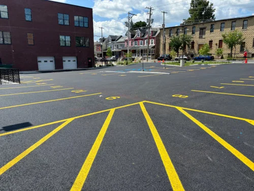 Side-by-side comparison of graded lot and newly paved parking lot demonstrating grading versus paving for commercial properties
