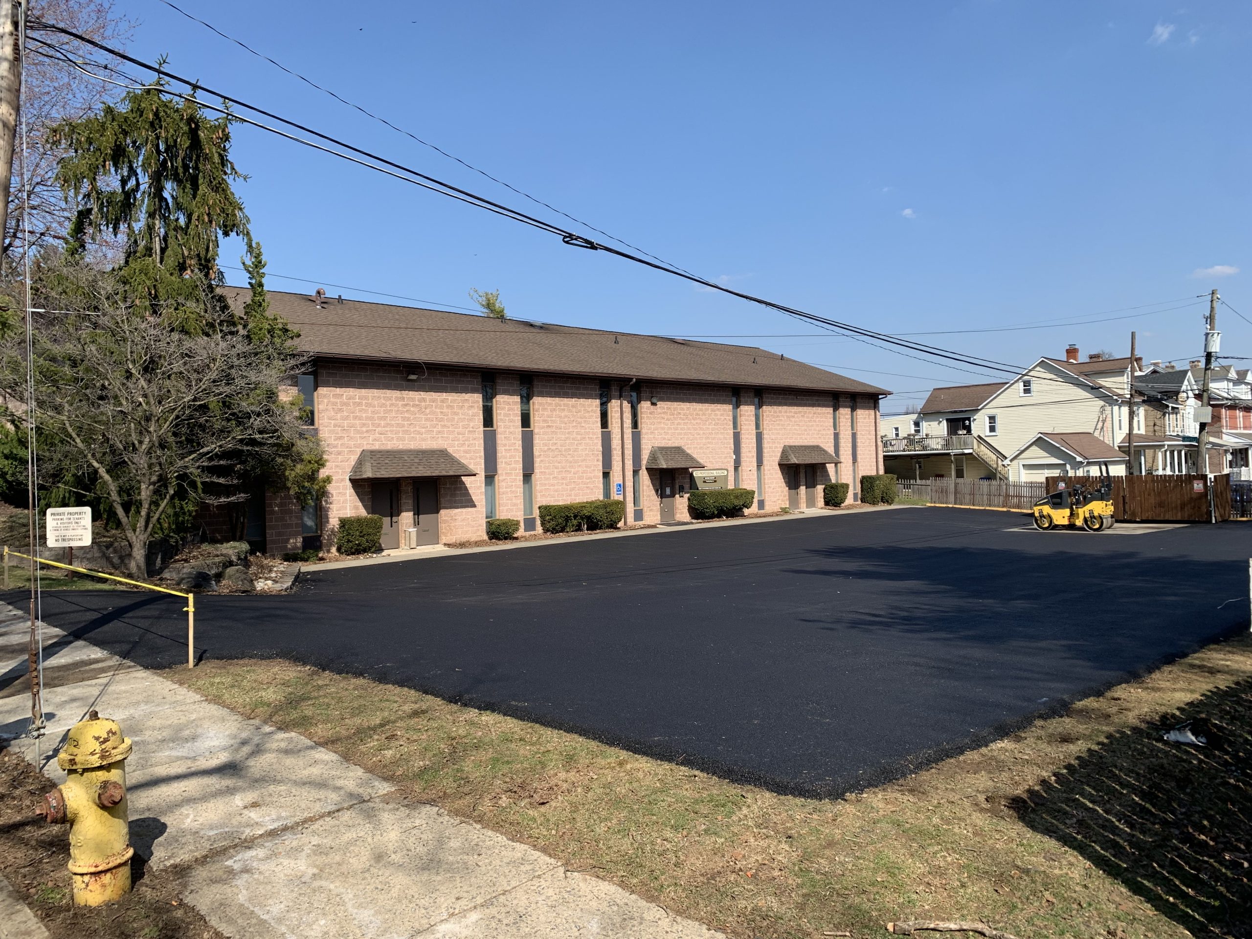 Business owner satisfied with a newly paved lot from a commercial paving company, highlighting curb appeal and professionalism.